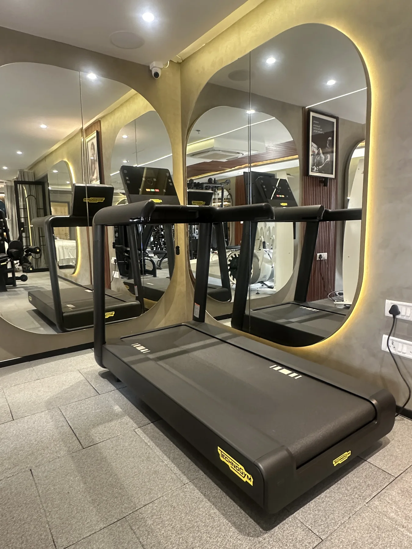A treadmill in front of the arched mirrors